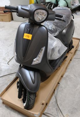un scooter qui se trouve dans un carton posé par terre