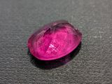 a close up of a pink gemstone on a black surface