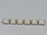 a close up of a silver bracelet on a table