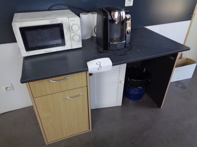 un micro-ondes et une cafetière posés sur un plan de travail