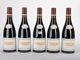 six bouteilles de vin sont alignées sur une surface blanche