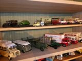 de nombreuses petites voitures et camions sur une étagère dans une pièce