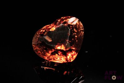 un losange orange sur une surface noire, avec un fond noir