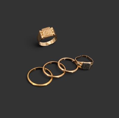 trois bagues en or et une bague en or sur fond noir