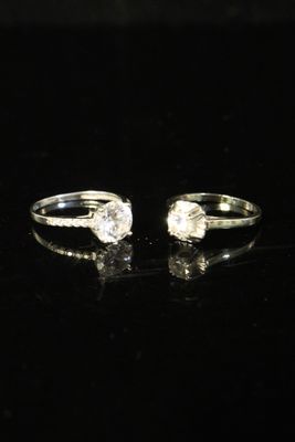a pair of engagement rings on a black surface