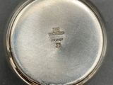 a close up of a silver pocket watch on a table