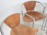 three wooden chairs sitting next to each other on a white surface