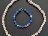 a close up of a necklace and bracelet on a black surface