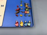 many figurines of people sitting on a blue tray