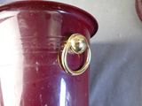 a red vase with a gold ring on it