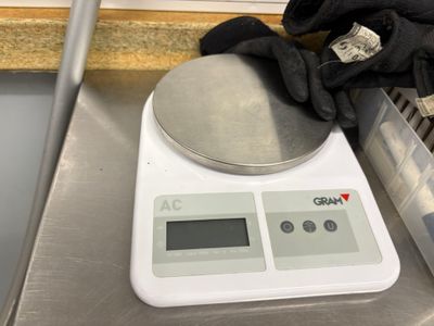 a digital scale with a glove on top of it