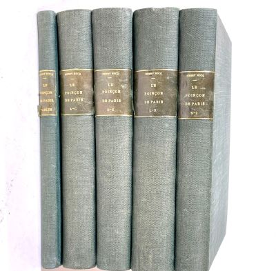 five books are lined up in a row on a white surface