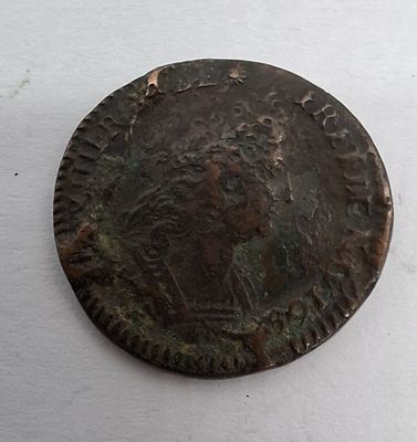 une image représentant une pièce de monnaie en bronze sur laquelle figure un homme