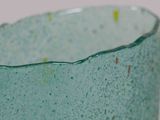 a close up of a green glass cup on a table