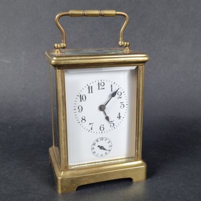 a small gold clock with a white face on a table