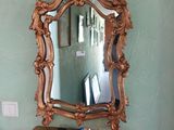 un miroir accroché au mur au-dessus d'une table sur laquelle se trouve un livre
