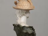 statue of a woman wearing a hat with horns on top of her head