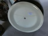 a white plate sitting on top of a table next to a vase