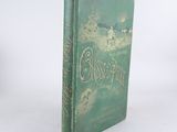 an old green book sitting on top of a white table