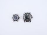 deux montres posées l'une à côté de l'autre sur une surface blanche