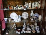une vitrine sur laquelle sont disposées de nombreuses pièces de vaisselle en porcelaine