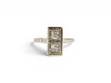 a close up of a ring with two diamonds on a white background