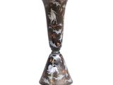 un vase posé sur un support sur une surface blanche