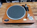une platine posée sur une table en bois, sur laquelle se trouve un micro