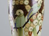a vase with a bird on it sitting on a table