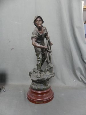 a statue of a man standing on top of a wooden base