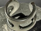 sterling silver ring with a curved design on top of a rock