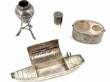 a silver boat and other silver objects on a white surface