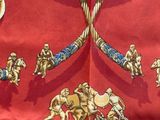 an image of a close up of a red shirt with gold and blue designs