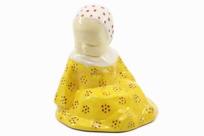 une figurine représentant une femme en robe jaune