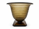 un vase en verre posé sur un socle en bois
