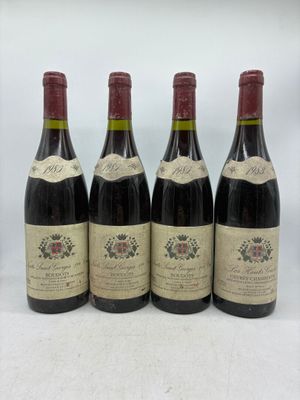 quatre bouteilles de vin sont alignées sur une surface blanche