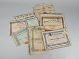 Plusieurs anciens certificats sont empilés les uns sur les autres sur une table
