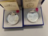 a couple of silver coins in a blue box on a table