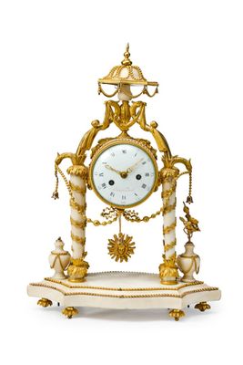 une horloge dorée et blanche posée sur un socle, sur une surface blanche