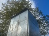 une grande boîte métallique posée au sommet d'un mur en béton