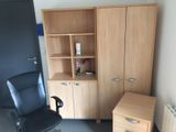 a desk with a chair and a cabinet in a room