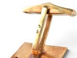 a close up of a gold cuff on a wooden stand