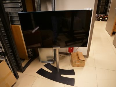 une télévision à écran plat posée sur un meuble au milieu d'une pièce