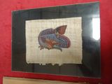 peinture représentant un poisson sur un morceau de tissu accroché à un mur rouge