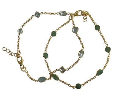 un gros plan sur un bracelet composé d'une chaîne en or et de perles de verre vertes