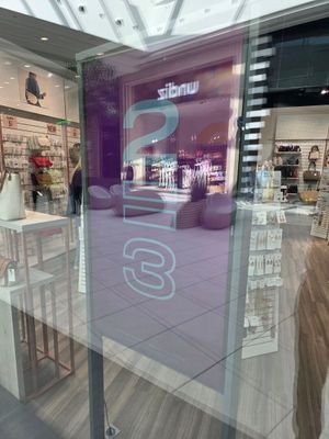 une devanture avec une porte vitrée et une enseigne dans la vitrine