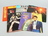 four elvis presley albums are on a table with a white background