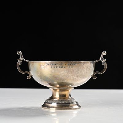 a silver cup on a white table with a black background