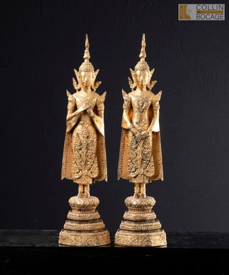 two gold statues of a woman and a man on a pedestal