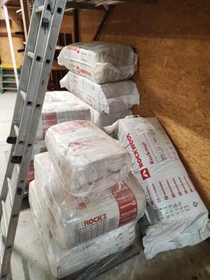 une échelle posée à côté d'une pile de sacs de ciment